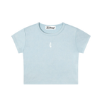A light blue short-sleeve crop top t-shirt with a small white teardrop logo on the center chest, displayed flat against a solid white background.
