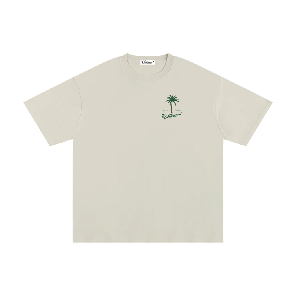 Beige t-shirt with palm tree design and text on a white background