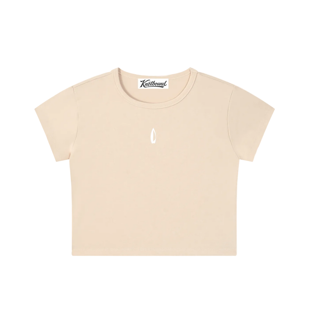 A light beige short-sleeve crop top t-shirt with a small white teardrop logo on the center chest, displayed flat against a solid white background.