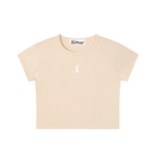 A light beige short-sleeve crop top t-shirt with a small white teardrop logo on the center chest, displayed flat against a solid white background.