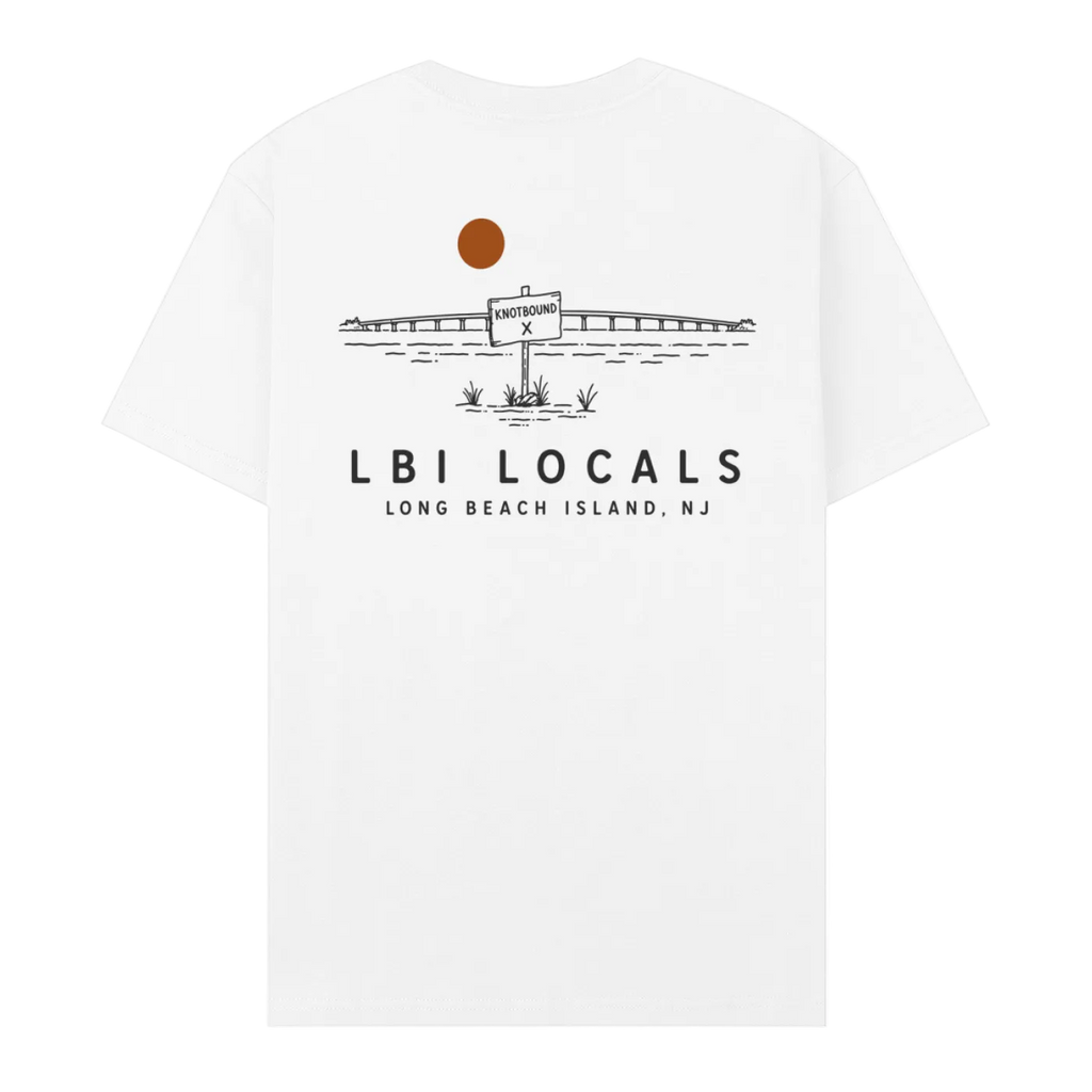 A white short-sleeve crewneck t-shirt with a black line art graphic of a bridge, a sign reading 'LONG BEACH ISLAND', and a brown sun on the back. Below the graphic, the text 'LBI LOCALS' and 'LONG BEACH ISLAND, NJ' is printed in black.