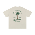 Beige t-shirt with palm tree graphic and text on a white background