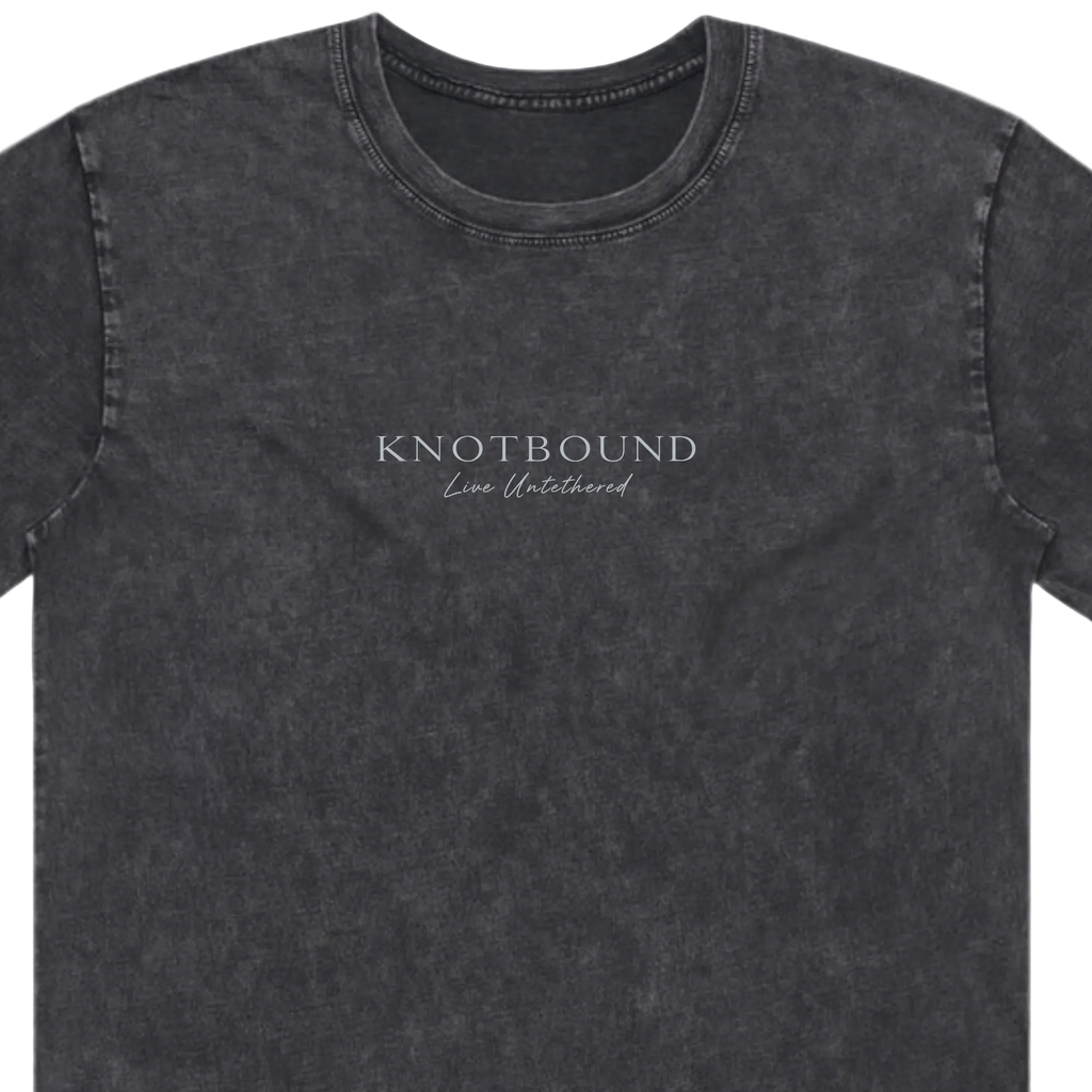 A dark gray mineral-wash crewneck t-shirt with 'KNOTBOUND' and 'Live Unleashed' printed in white on the chest, shown against a plain white background.