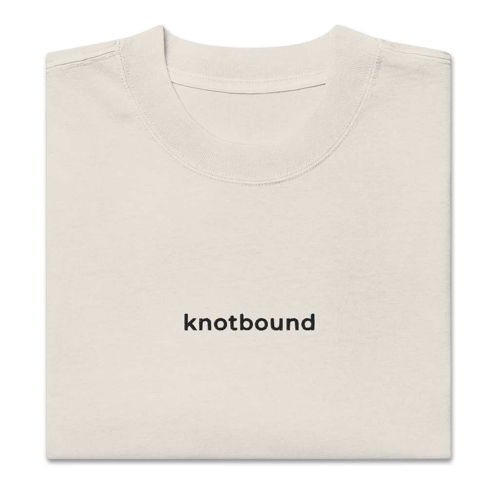 A folded off-white crewneck t-shirt with the word 'knotbound' printed in black lowercase sans-serif font on the chest, shown on a plain white background.
